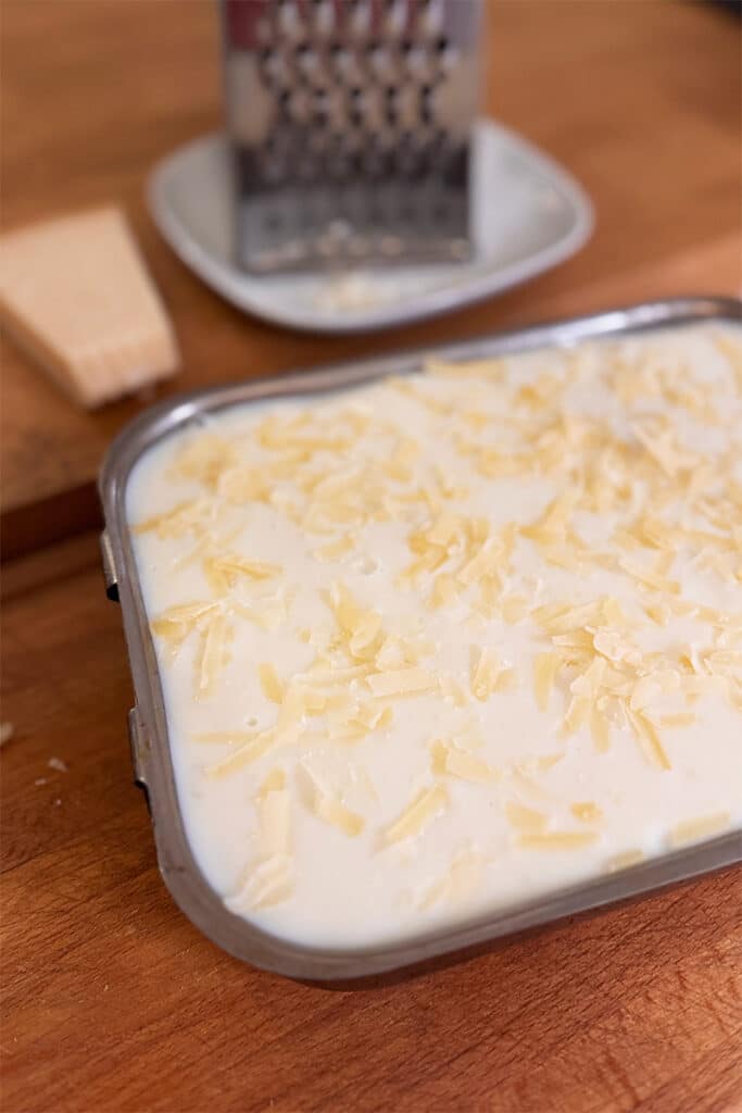 plat de lasagnes au poulet et poireaux dans un plat en fer et prêt à être mis au four
