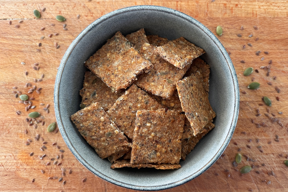 Crackers maison croustillants aux farines complètes et aux graines, servis dans un bol pour un apéritif sain