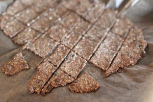 Crackers maison dorés après cuisson au four sur une plaque recouverte de papier cuisson