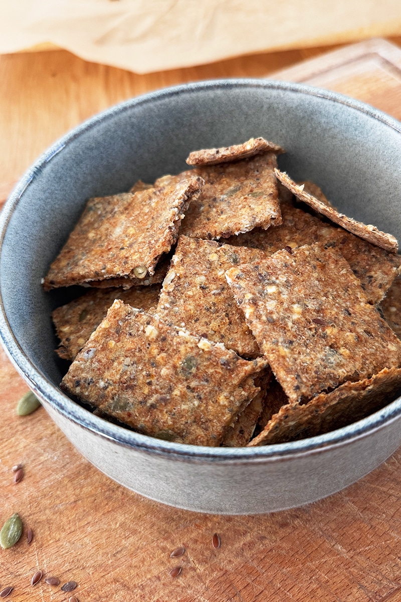 Crackers maison croustillants aux farines complètes et aux graines, servis dans un bol pour un apéritif sain