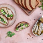 Tartines de pain complet garnies de sardines à l’huile, riches en oméga-3, un poisson gras bénéfique pour le cholestérol